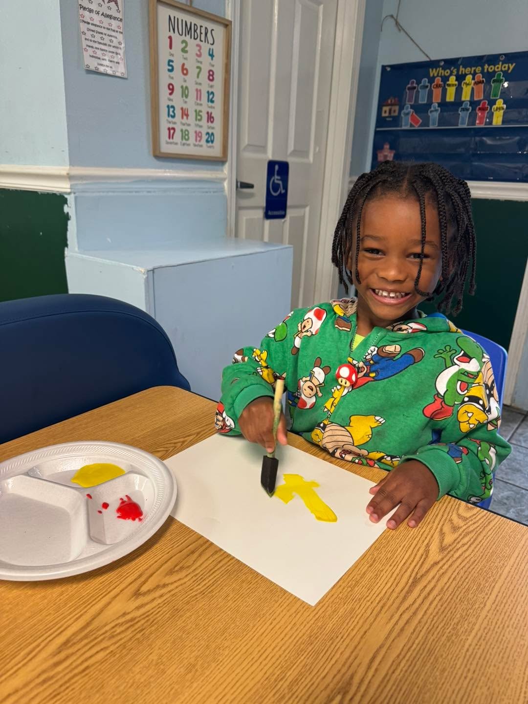 Child painting at a classroom table at Gulfport Academy