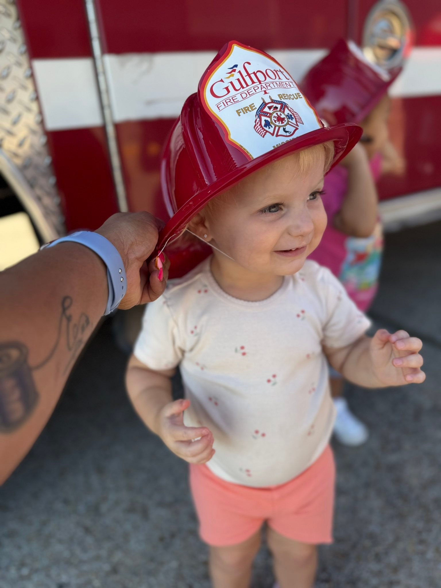 Toddler wearing a Gulfport Fire Department helmet